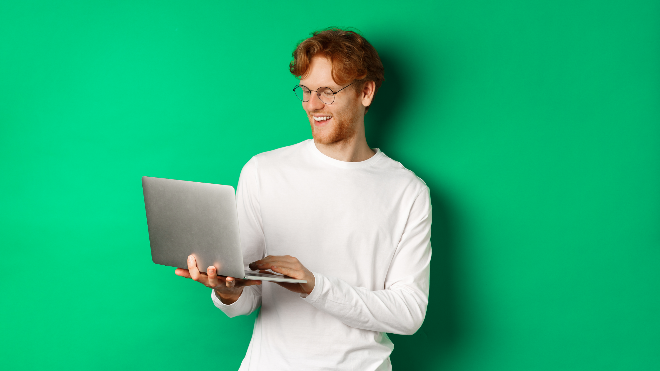 homme qui rigole avec un ordinateur sur un fond vert